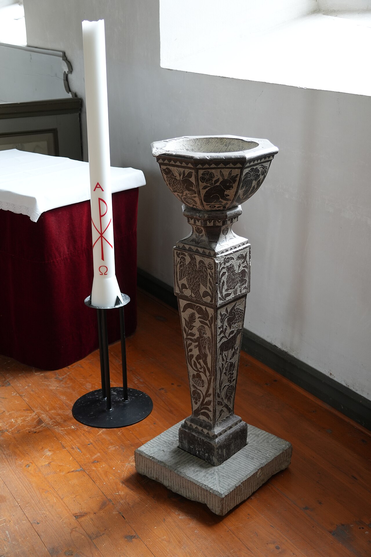 Døpefont og lys i en kirke.